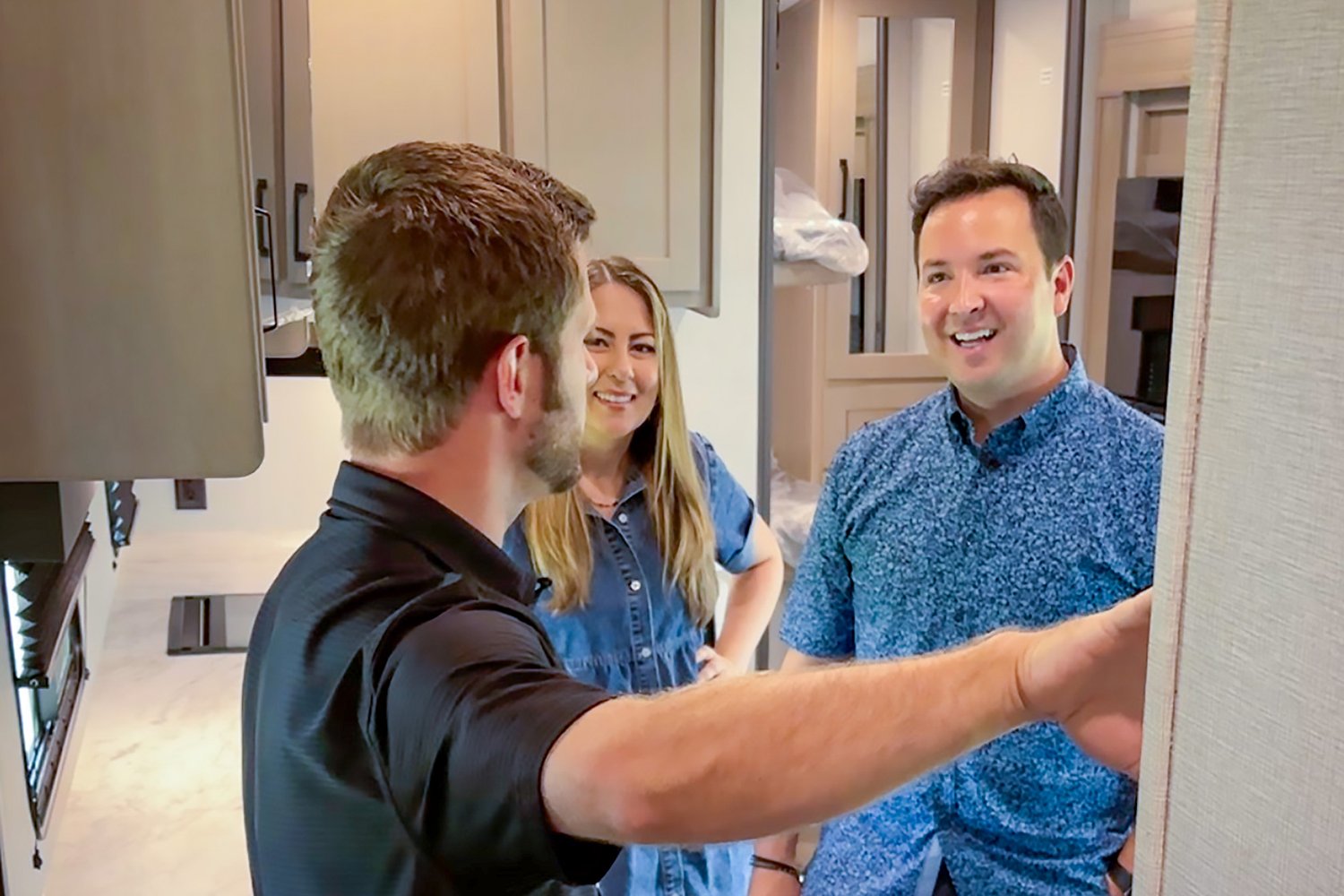 A Venture RV representative talking with a couple inside a new fifth wheel